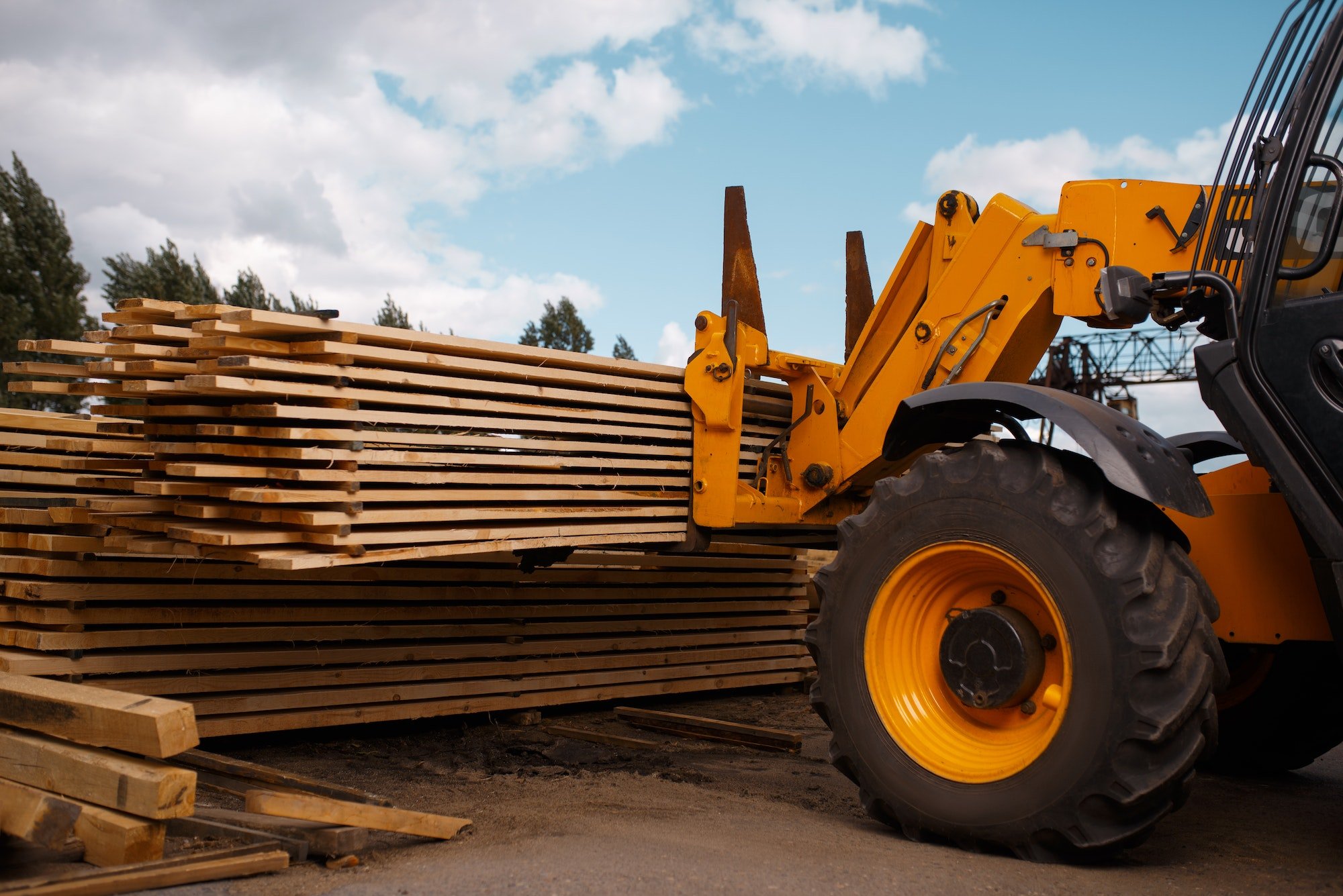 Forklift loads the boards in the lumber yard