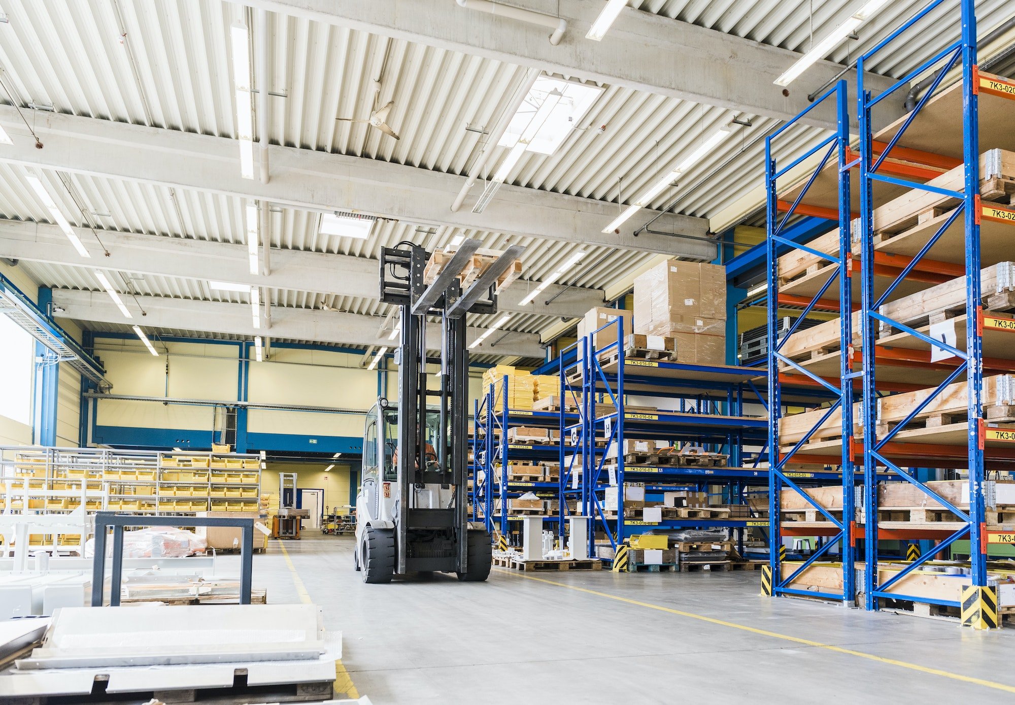 Man on forklift in factory warehouse