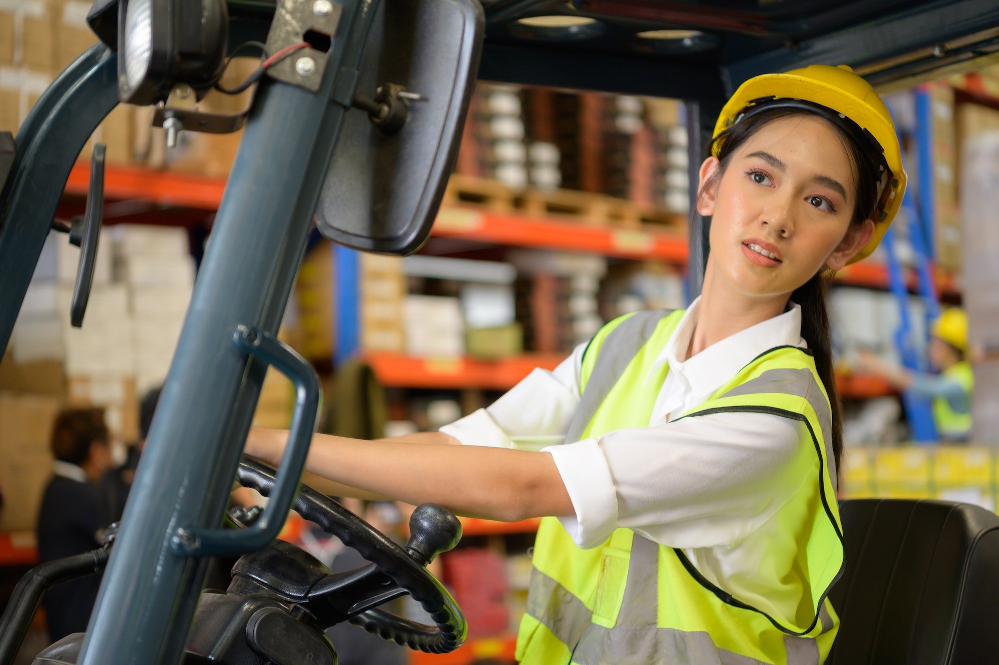 Female worker driving a forklift moving goods in the warehouse Practicing forklift operation