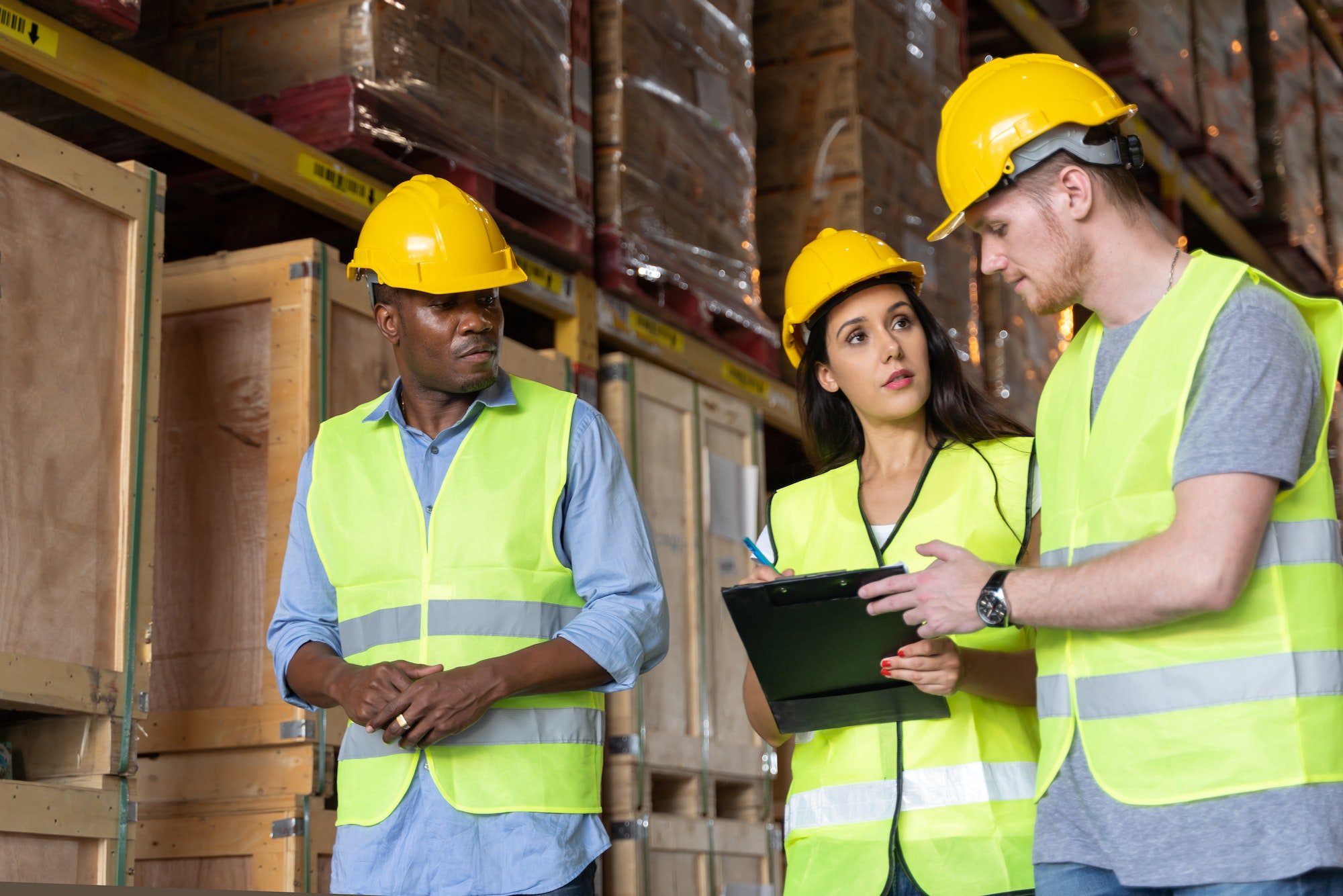 Three male and female warehouse workers are working in a warehouse